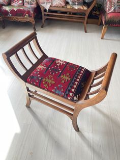 a wooden rocking chair sitting on top of a white floor next to a red couch