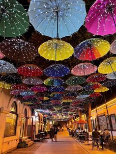 many colorful umbrellas are hanging from the ceiling