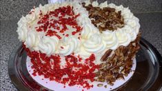 a cake with white frosting, red and white sprinkles on it