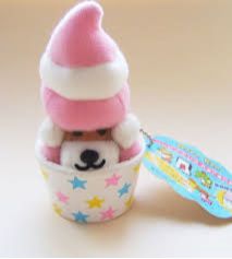 a small stuffed animal with a pink hat in a cup