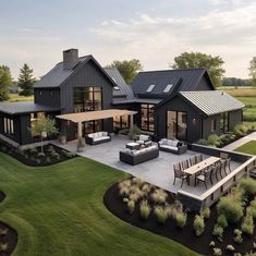 an aerial view of a modern house with patio and outdoor furniture in the foreground