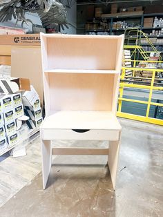 a white wooden bench sitting inside of a warehouse