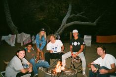 a group of people sitting around a fire pit