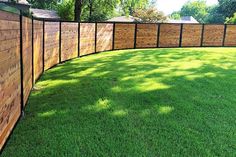 a wooden fence in the middle of a grassy yard