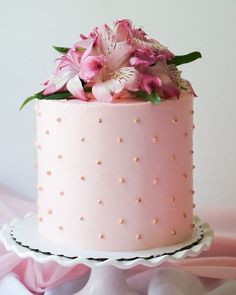 there is a pink cake with flowers on it