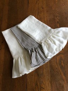 three pieces of white and black cloth on a wooden floor, folded up in half