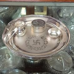 an ornate glass dish with two silver candles on the lid and several other dishes around it