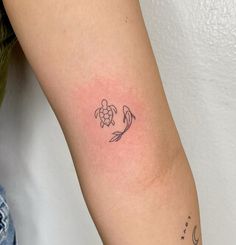 a small tattoo on the arm of a woman with a turtle and moon in it