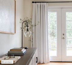 a living room with white curtains and a door