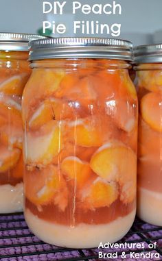 three jars filled with peach pie filling sitting on top of a purple shelf next to a wire rack