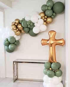 a cross and balloon garland on the wall