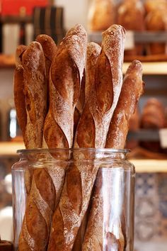 some bread sticks are in a glass jar