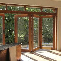 an empty room with sliding glass doors and a tub in the middle, on tiled flooring