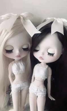 two dolls are sitting next to each other