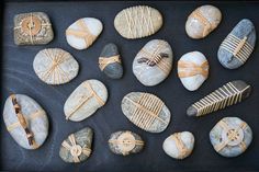 some rocks are wrapped in gold ribbon and sitting on a black surface with other rocks