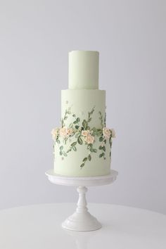 a three tiered cake with flowers painted on it