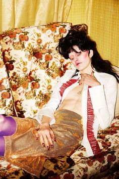 a woman sitting on top of a couch next to a wall