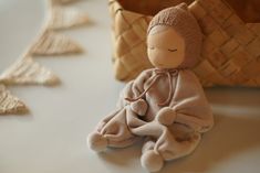 a stuffed doll sitting on top of a table next to a basket and other items