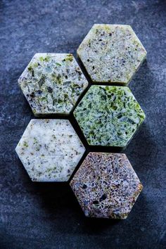 four hexagonal pieces of soap sitting next to each other on a black surface