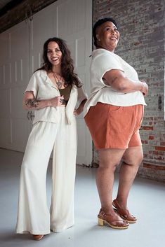 two women standing next to each other in front of a garage door