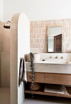 a bathroom with two sinks and a mirror on the wall next to a towel rack