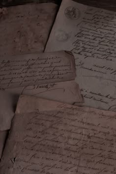 several old papers are piled on top of each other in an antique style setting with writing