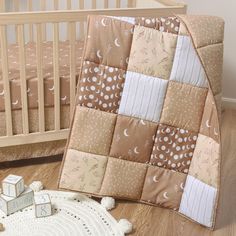 a baby crib with a teddy bear next to it and a blanket on the floor