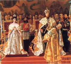 the coronation of king and queen of england, with their families in gold robes on red carpet