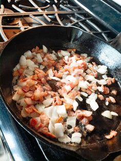 a skillet with onions and meat cooking on the stove