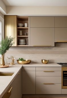 a kitchen with white counter tops and gold accents on the cabinets, along with an oven