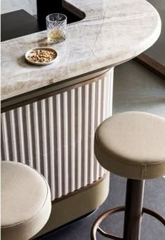 two bar stools sitting next to each other in front of a counter