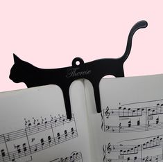 an open book with musical notes and a cat's tail sticking out of it