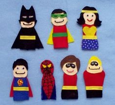 the paper dolls are made to look like superheros and their faces have been cut out