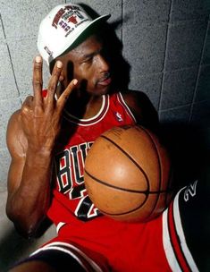 a man holding a basketball in front of his face