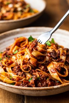 a fork full of pasta with meat and sauce