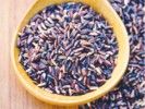 a wooden bowl filled with purple sprinkles on top of a wooden table