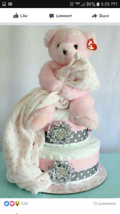 a pink teddy bear sitting on top of a cake