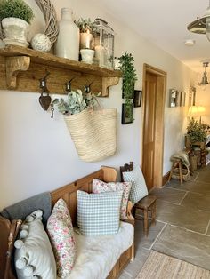 a living room filled with lots of furniture and plants on top of wooden shelves next to a doorway