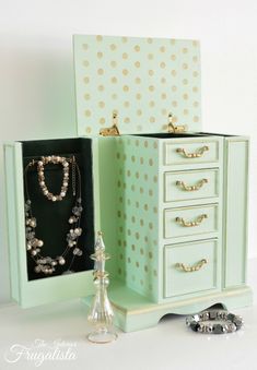 an open jewelry box sitting on top of a table next to a vase and other items