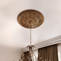 a chandelier hanging from the ceiling in a room with curtains and drapes