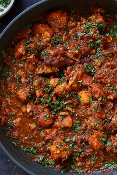 a pan filled with meat and sauce on top of a table