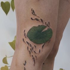 a close up of a person's legs with tattoos on them and leaves coming out of the leg