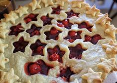 a pie with cherries on it sitting on a table