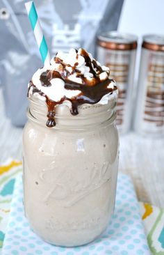 a mason jar filled with ice cream and topped with a chocolate sauce drizzle