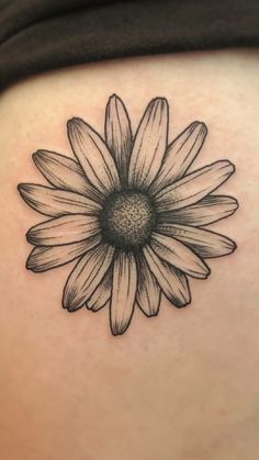 a black and white photo of a flower on the back of a woman's stomach