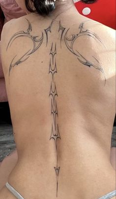 the back of a woman's body with tattoos on her upper and lower back