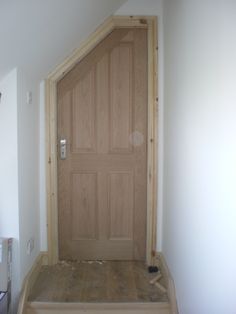 a wooden door in the corner of a room