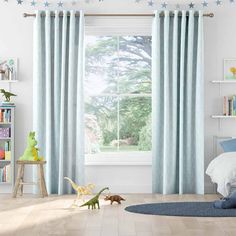 a child's bedroom with blue curtains and toys