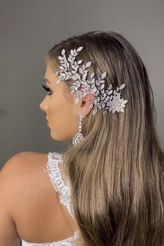 a woman wearing a bridal hair comb with leaves on it's head and pearls in her hair