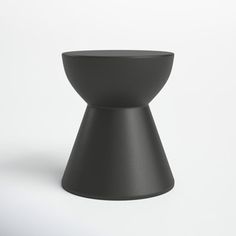 a black vase sitting on top of a white table